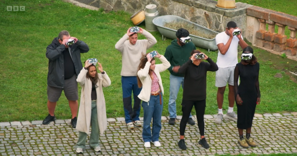 Group of people wearing VR headsets outdoors.