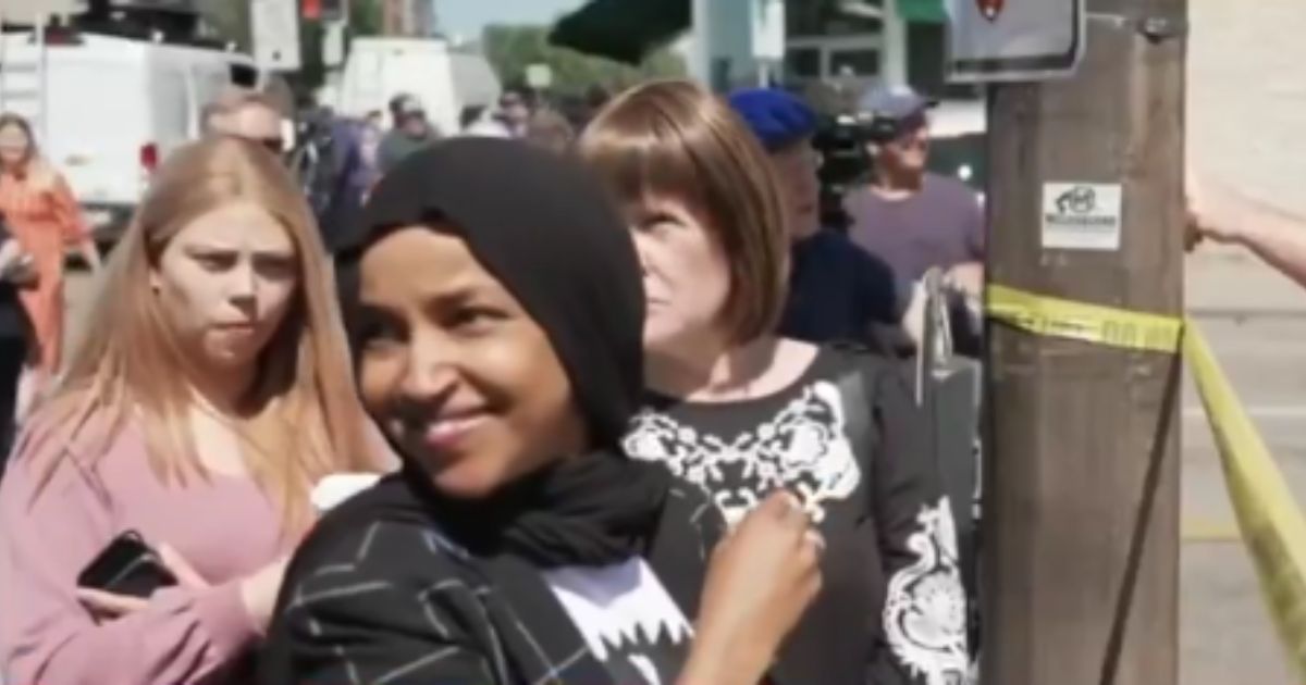 Rep. Ilhan Omar was seen smiling as she visited the Annunciation Catholic School, where two children were killed in a mass shooting, on Wednesday in Minneapolis, Minnesota.