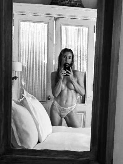 Black and white mirror selfie of Ellie Goulding in lingerie.