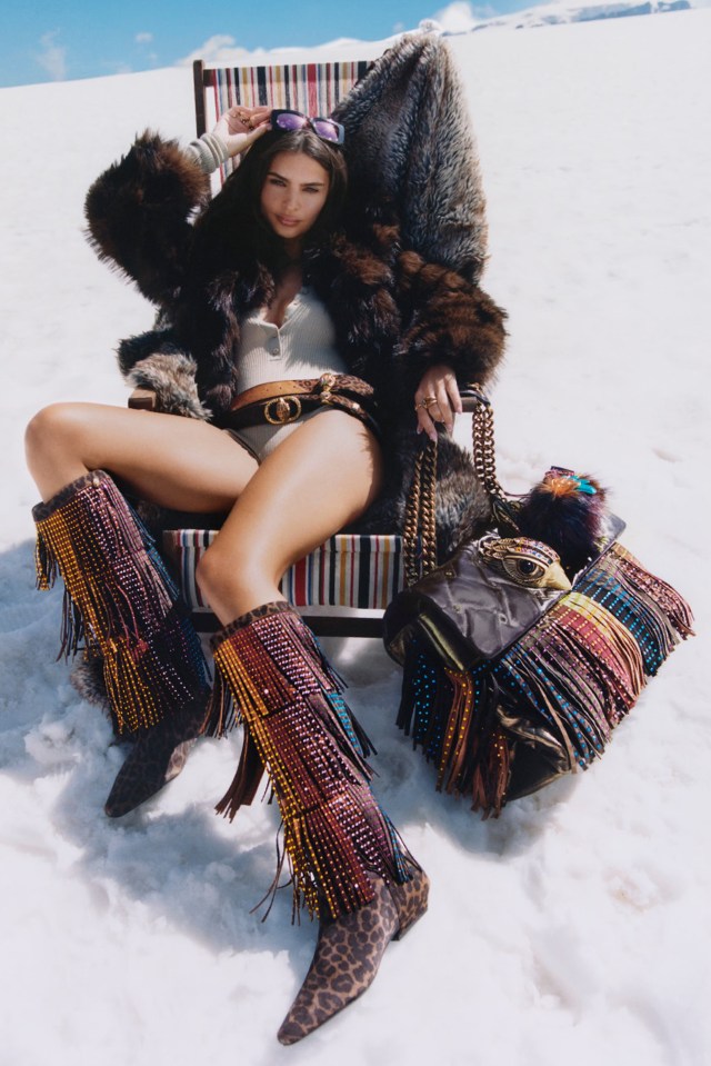 Emily Ratajkowski in a winter photoshoot wearing a fur coat, leopard print boots, and Kurt Geiger handbag.
