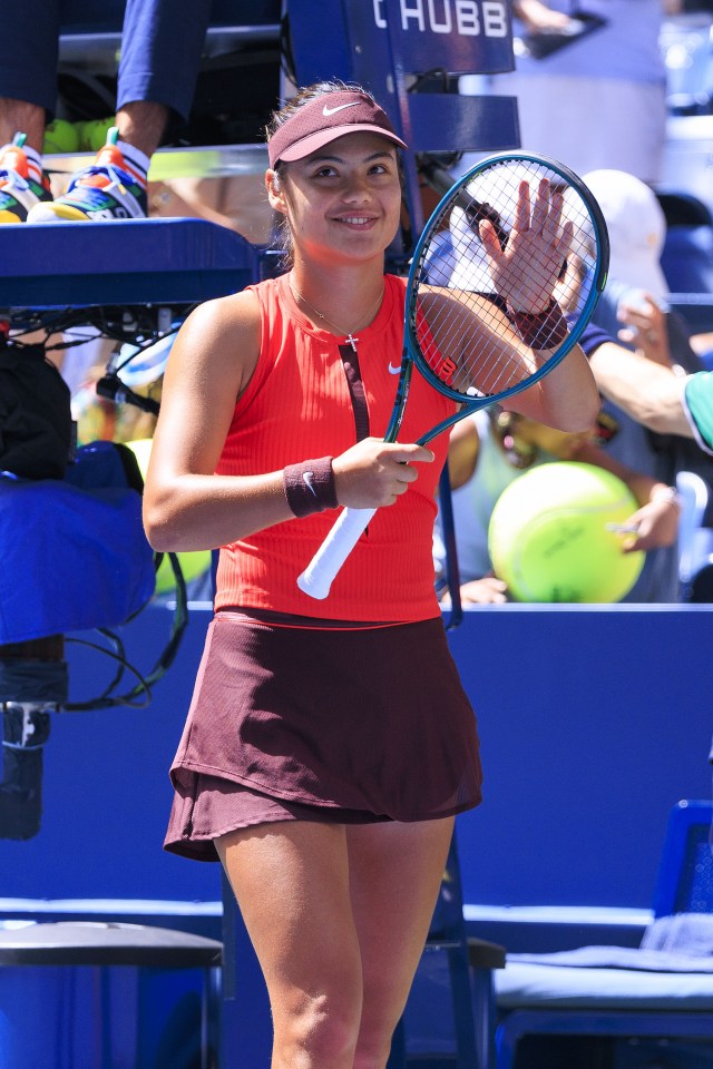 Emma Raducanu waves to fans after a tennis match.