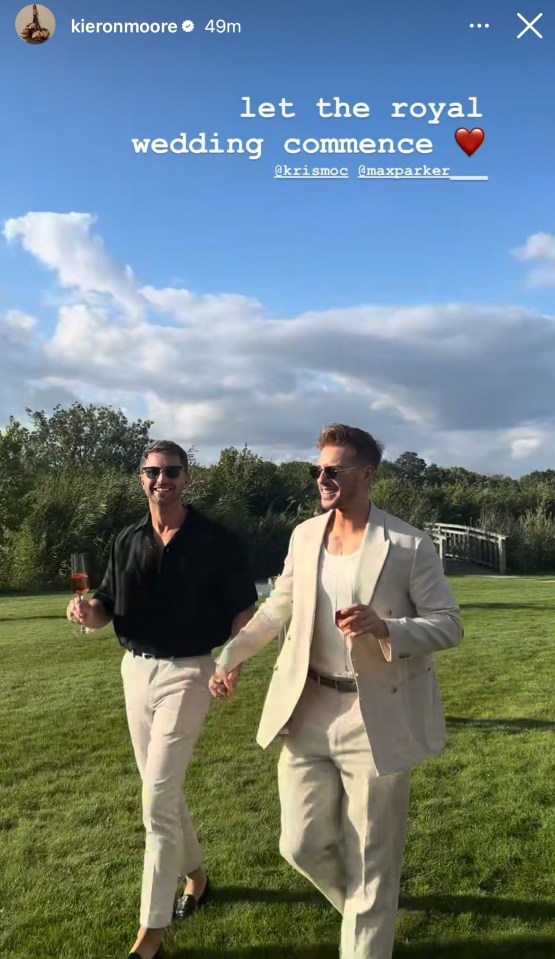 Two men holding hands at a wedding.