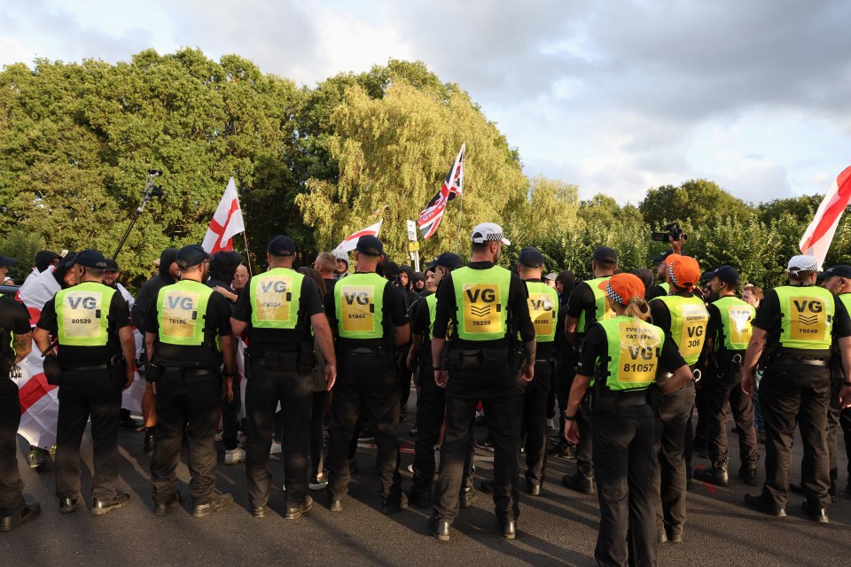 Police officers contain protesters.