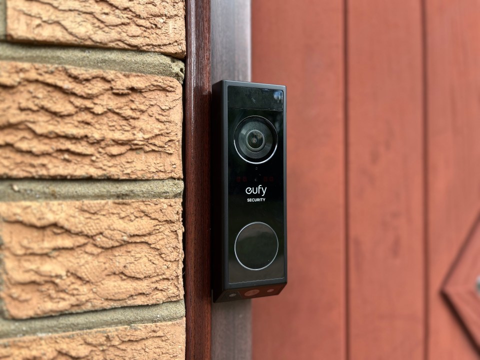 Eufy Security video doorbell mounted on a brick wall.