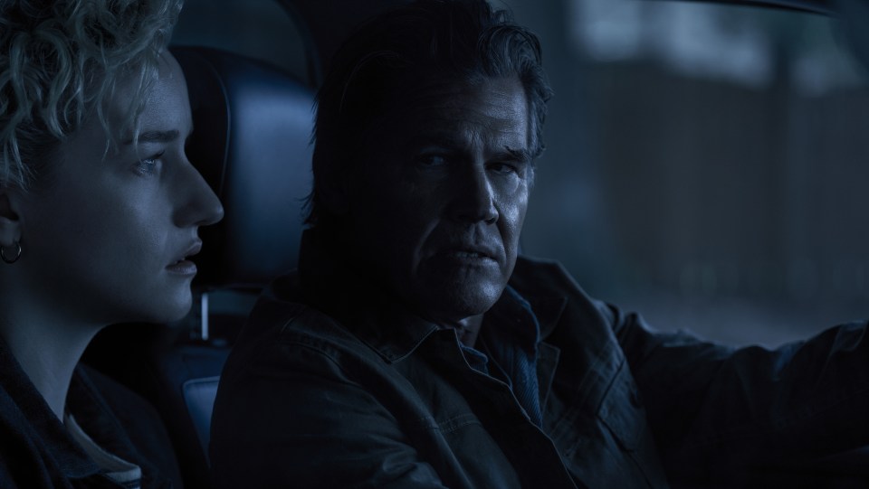 Still from *Weapons* showing Julia Garner as Justine and Josh Brolin as Archer in a car.