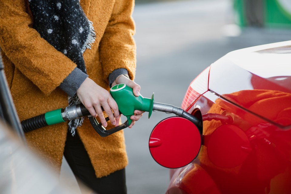 Woman pumping gas into her car.