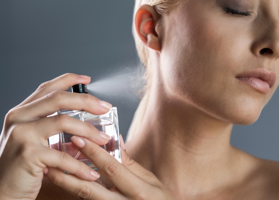 Woman applying perfume.
