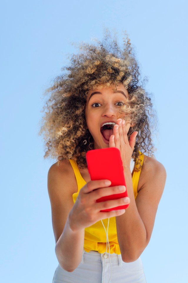Woman looking surprised at her phone.