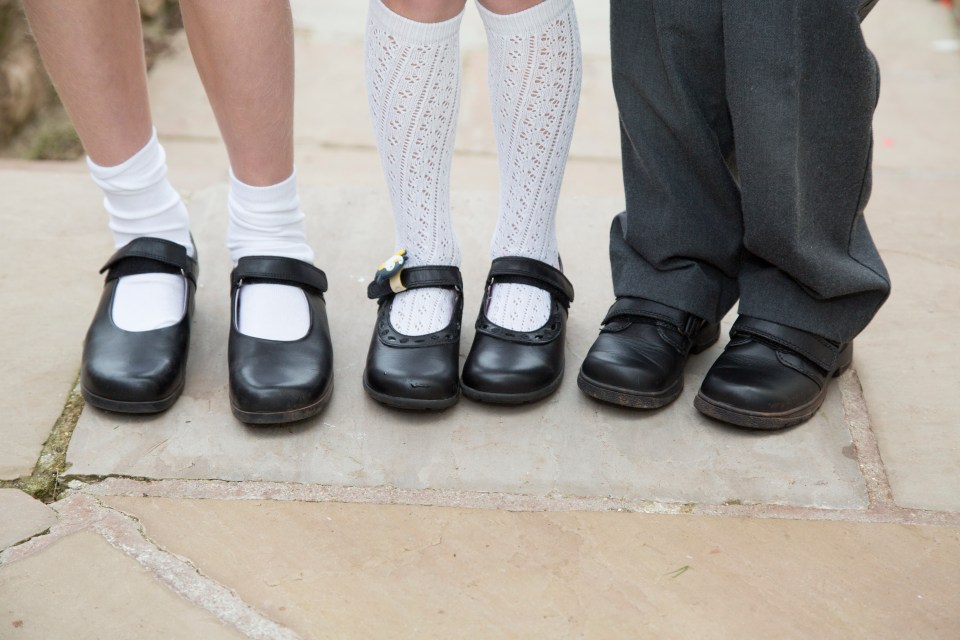 Three children's feet in new school shoes.