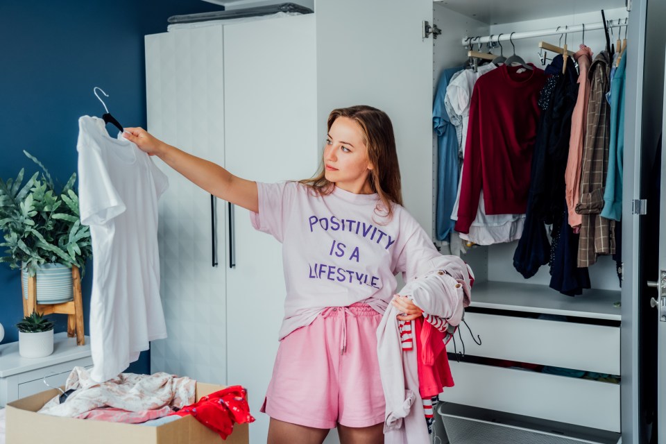 Woman sorting through clothes to donate to charity.