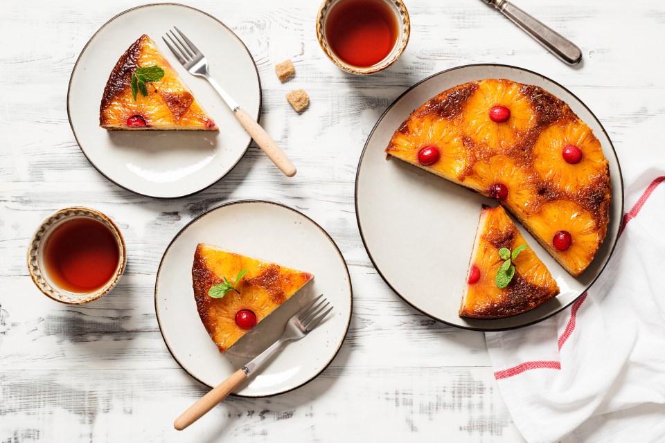 Pineapple upside-down cake with cranberries, served with tea.