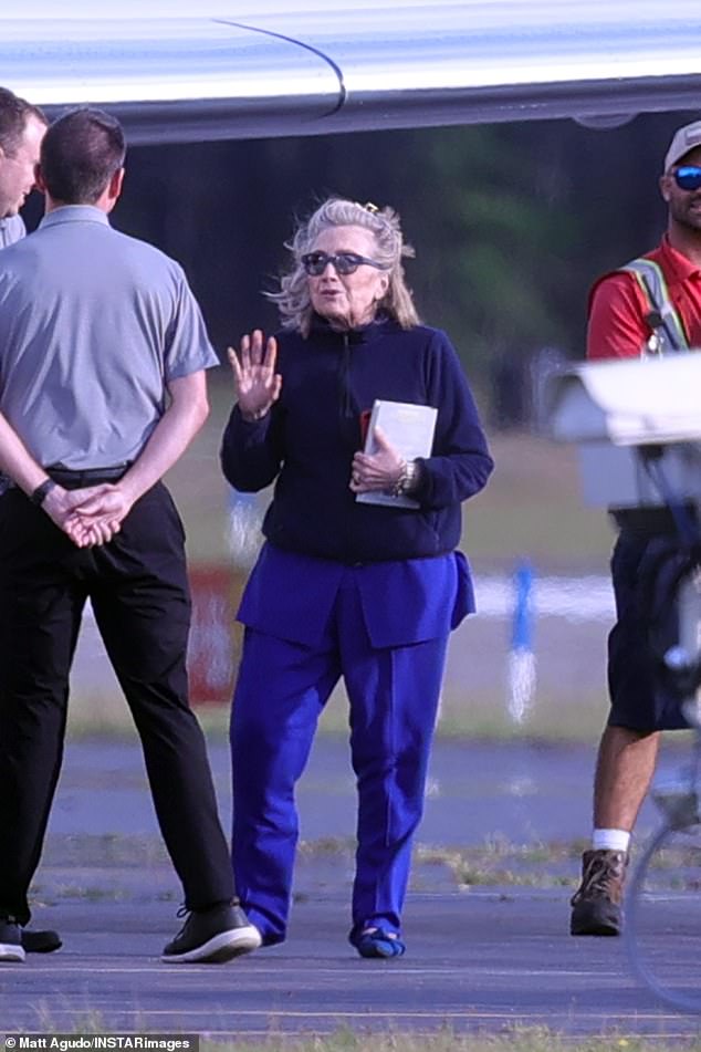 His wife and Former Secretary of State, Hillary Clinton, put a black sweatshirt over her blue two-piece set for their flight