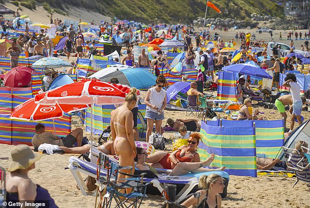 People working from home are reportedly clocking off early on Fridays during summer to grab pints at a beer garden (people are pictured on a beach in Newquay, Cornwall, on a busy Friday)