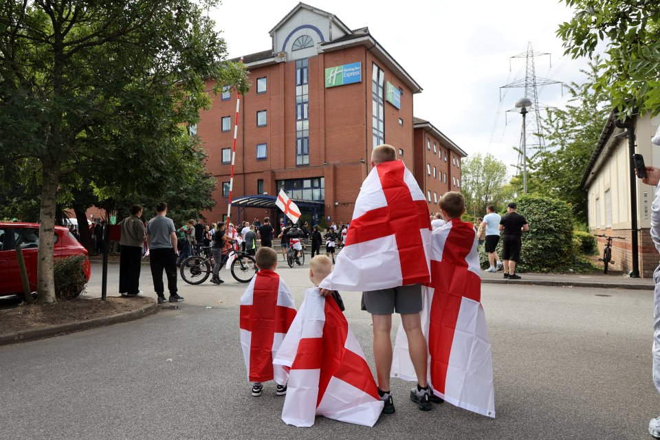 Protestors with English flags outside a Holiday Inn Express.