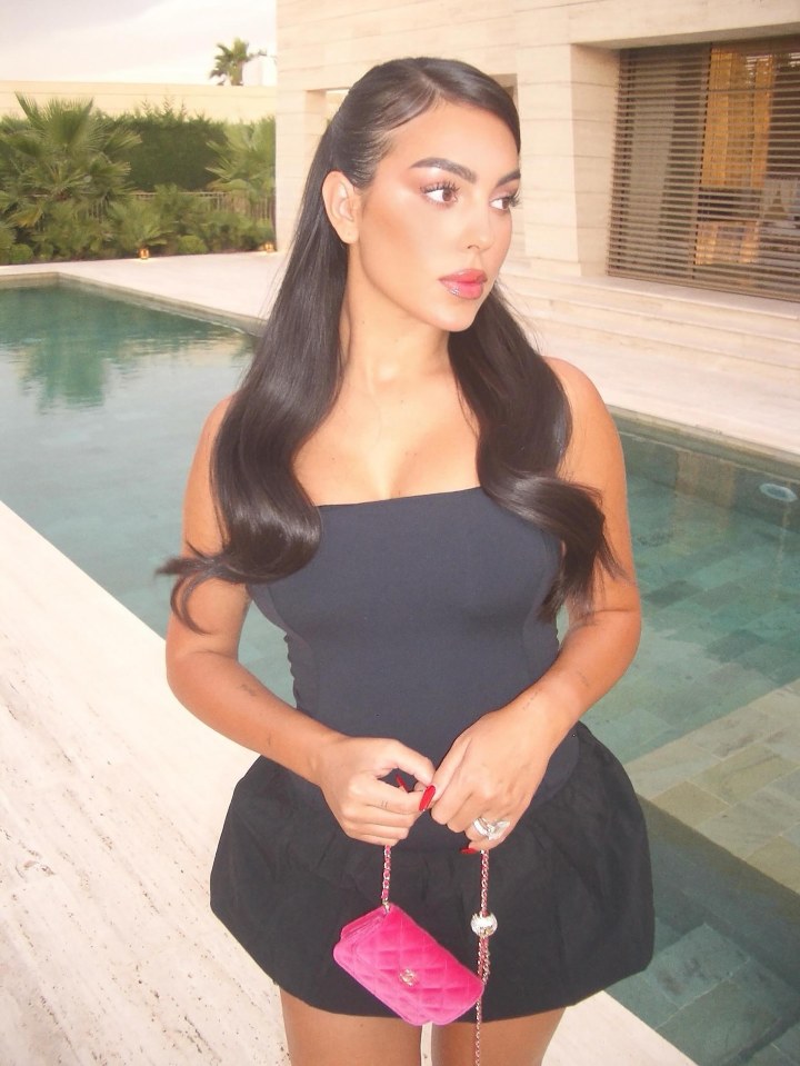 Woman in black dress by a pool.