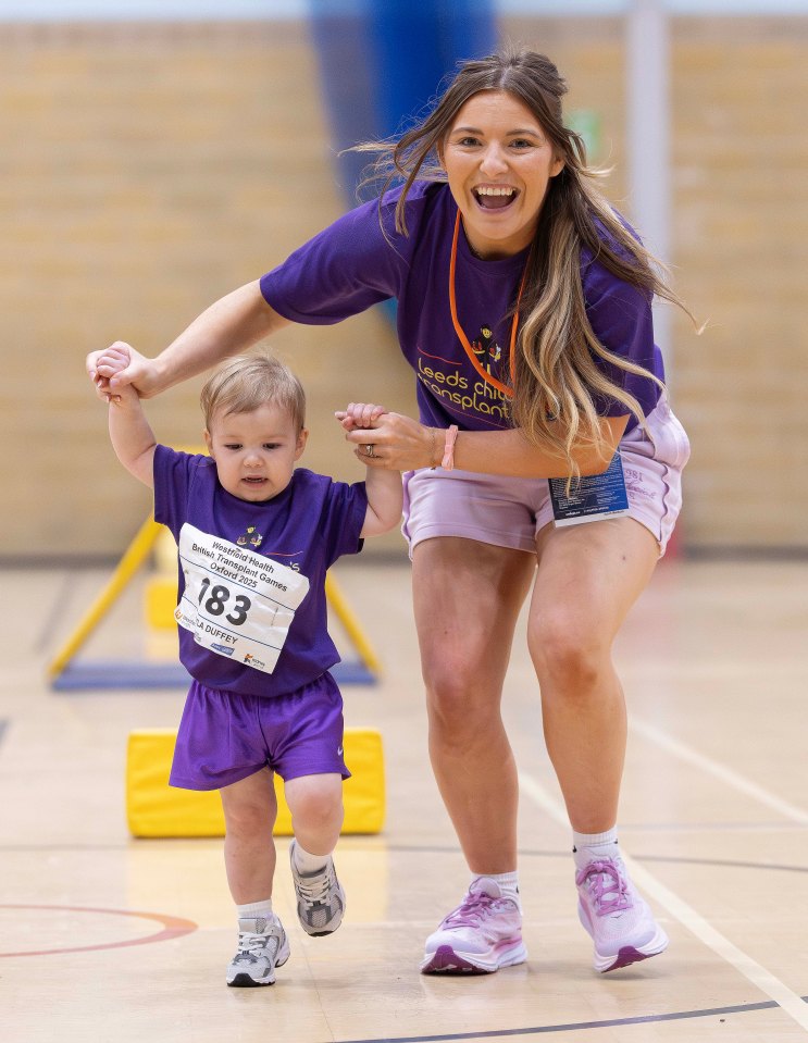 A young girl participates in an obstacle course, assisted by her mother.