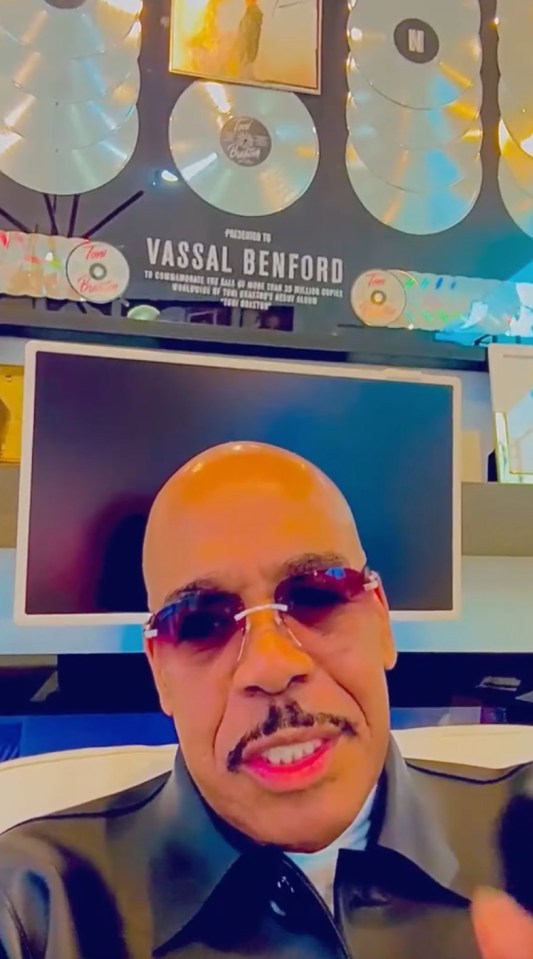 Vassal Benford in an interview, with awards on the wall behind him.