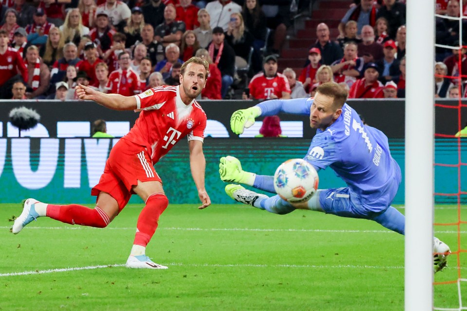 Harry Kane scoring a goal during a soccer game.