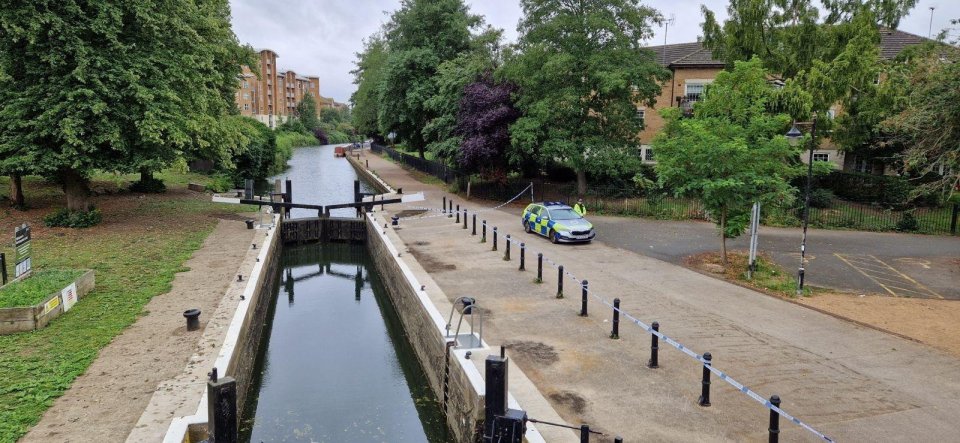 Police car at a crime scene near a canal.