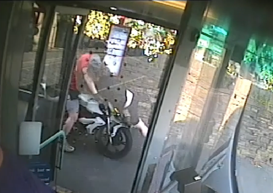 Person riding a motorcycle onto a bus.