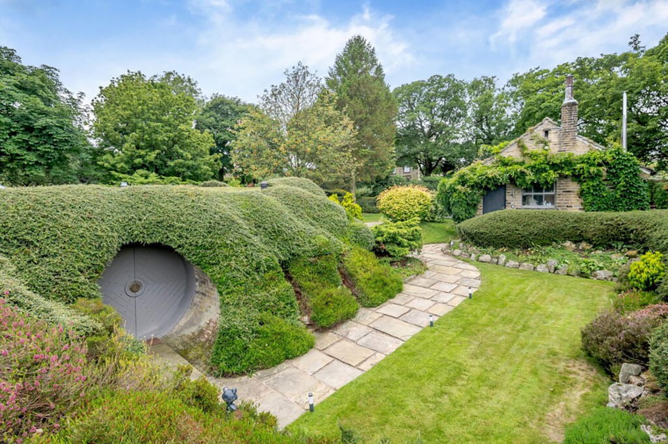 Earth-sheltered home with a round door and stone pathway.