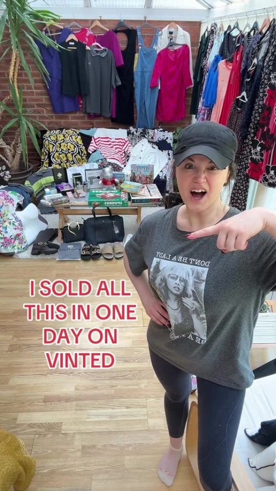 Woman pointing at a large amount of clothing and other items she sold in one day on Vinted.
