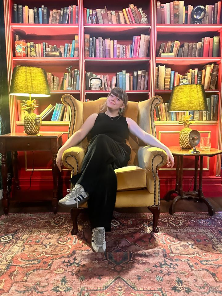 Woman sitting in an armchair in a library.