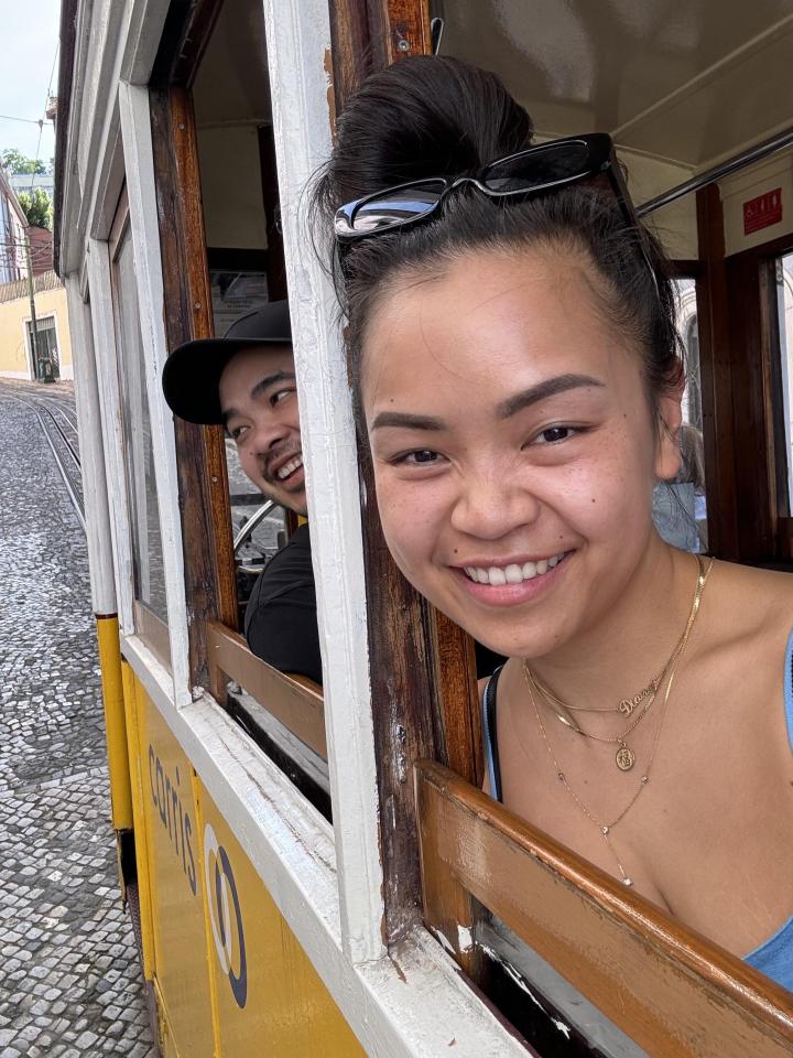 Two people smiling in a yellow tram.