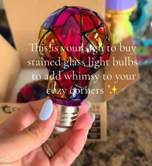 Hand holding a stained-glass lightbulb.