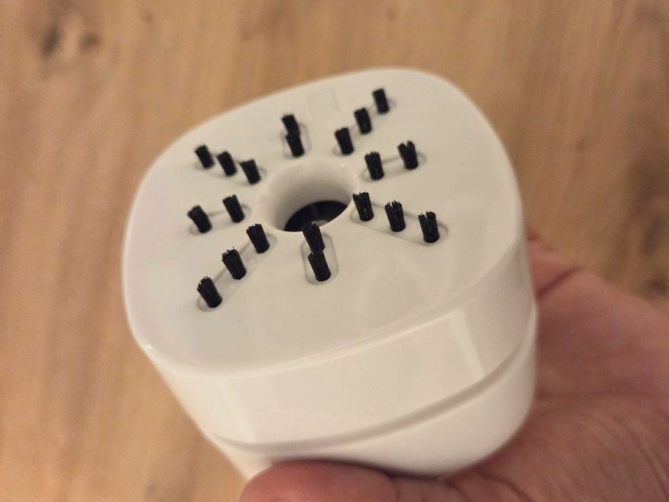 Close-up of a white device with small black brushes.