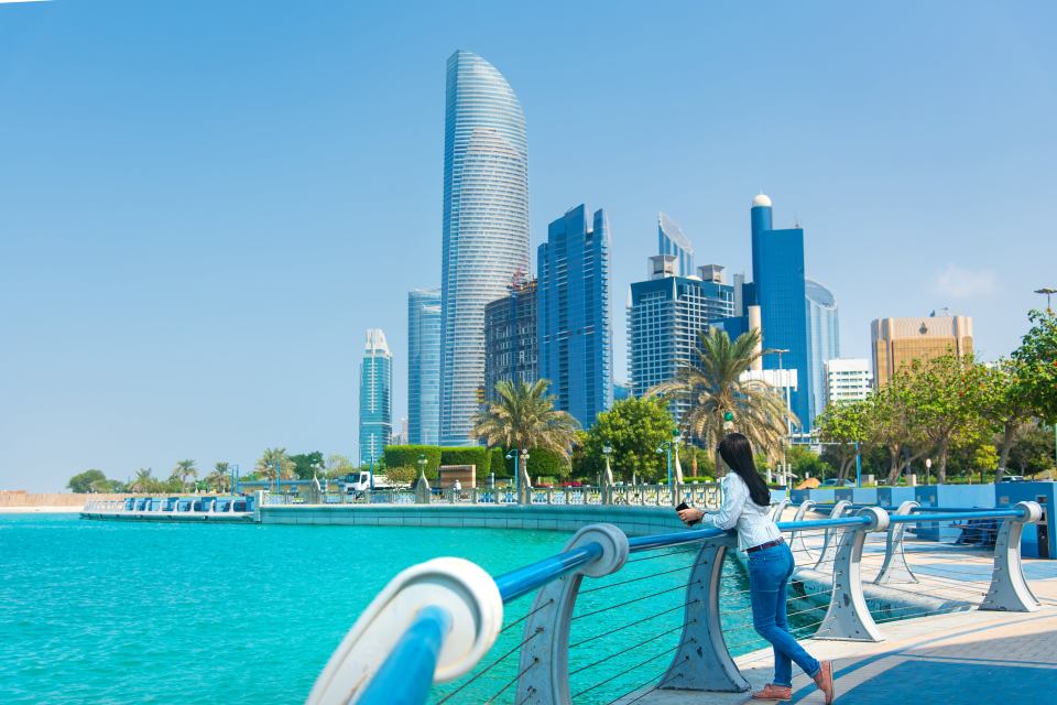 Woman overlooking waterfront cityscape.