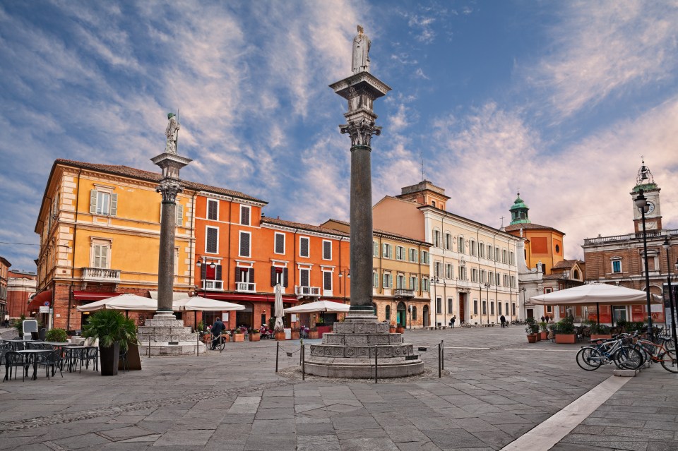 Piazza del Popolo in Ravenna, Italy, with columns topped with statues and surrounding buildings.