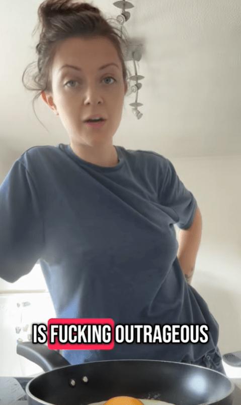 Woman cooking an egg while saying "is fucking outrageous" in a video still.