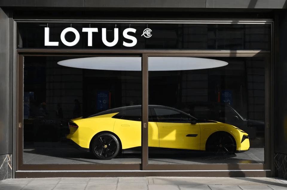 Yellow Lotus car in a showroom window.