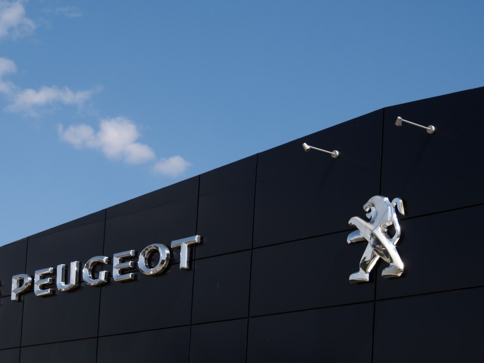 Peugeot logo on a dealership building.