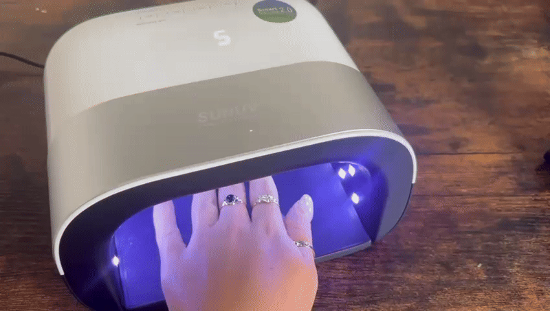 Hand under a UV nail lamp.