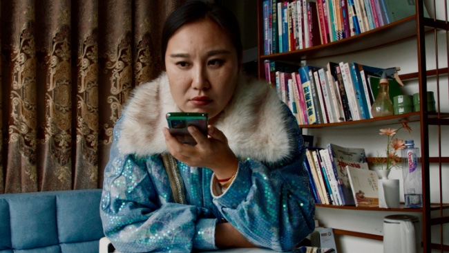 Still from the film *Mistress Dispeller*, directed by Elizabeth Lo.  A woman uses a smartphone.