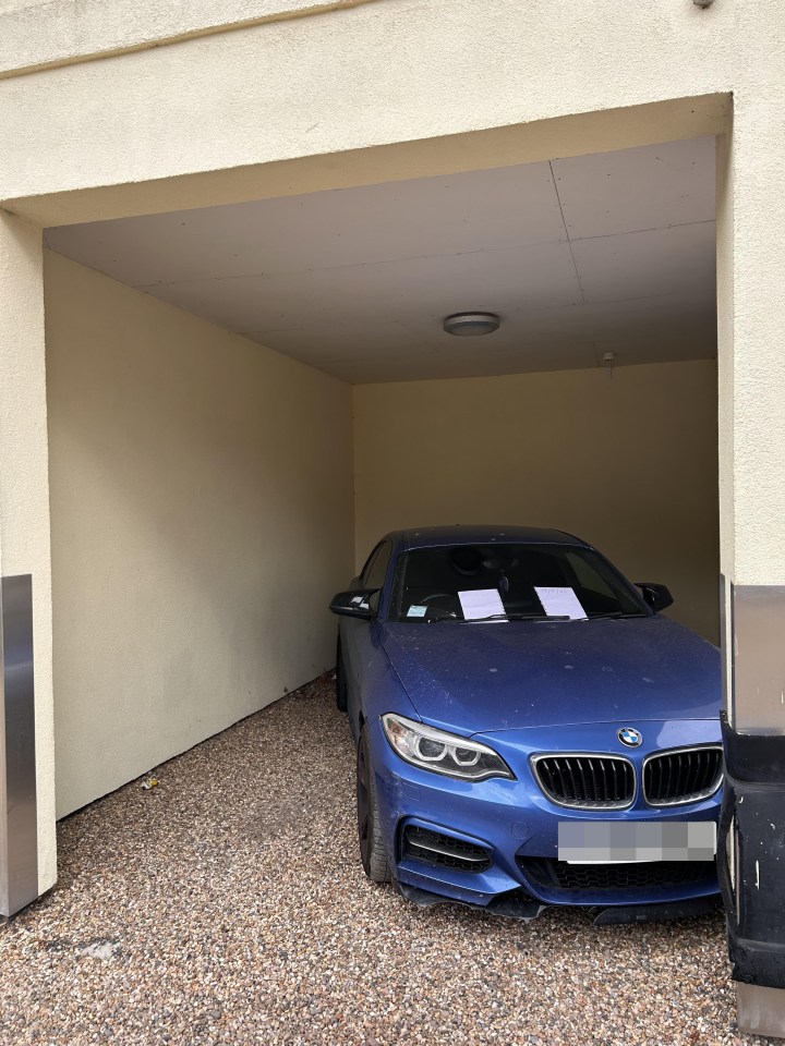Blue car illegally parked in a private space.