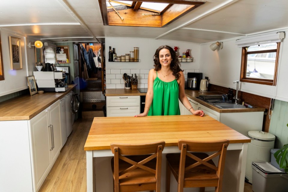 Woman standing in her houseboat kitchen.