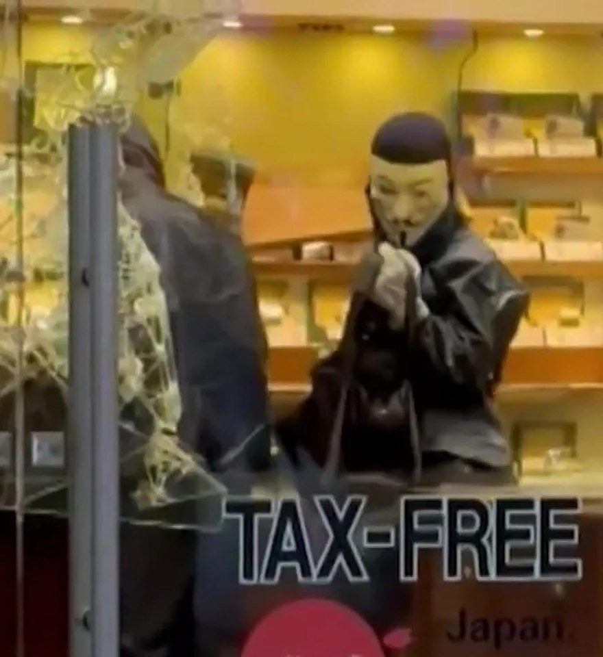 Person in Guy Fawkes mask during Ginza robbery.