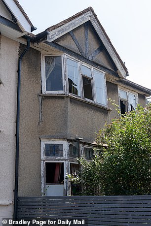 The windows are smashed, the front of the house is held up with an acrow prop