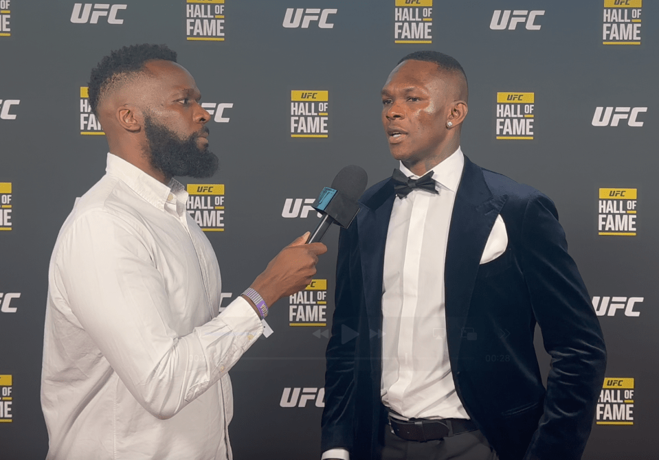 A man in a suit being interviewed at a UFC Hall of Fame event.