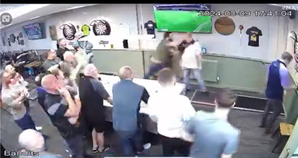 Security camera footage of a darts player punching a rival after a match.
