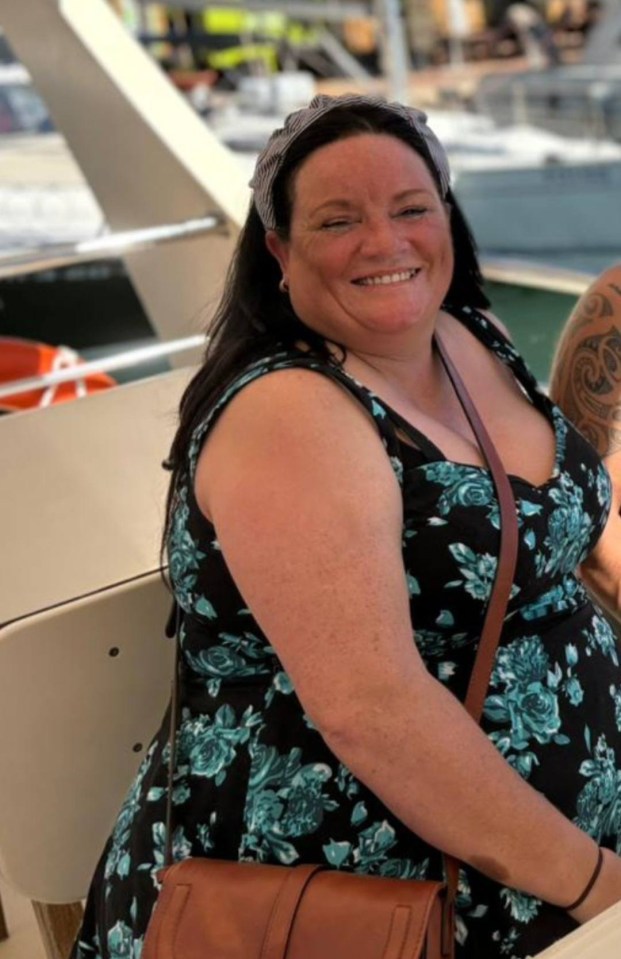 Woman in floral dress smiling on a boat.
