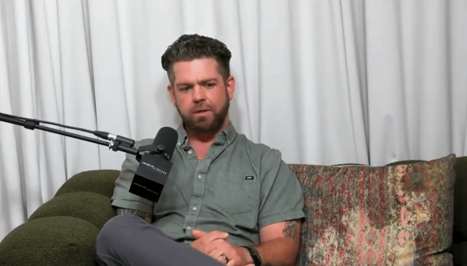 Man sitting on a couch during a podcast interview.
