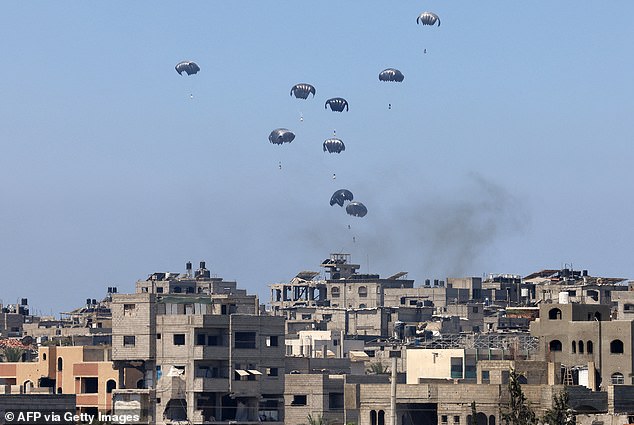Aid pallets are parachuted after being dropped from a military plane over Nuseirat in Gaza
