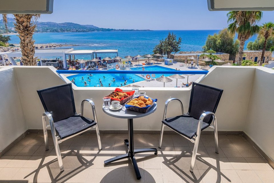Hotel balcony with breakfast and ocean view.