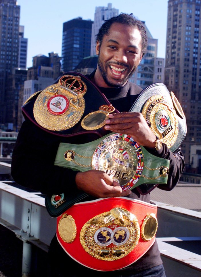 Lennox Lewis, undisputed world heavyweight boxing champion, displays his four championship belts.