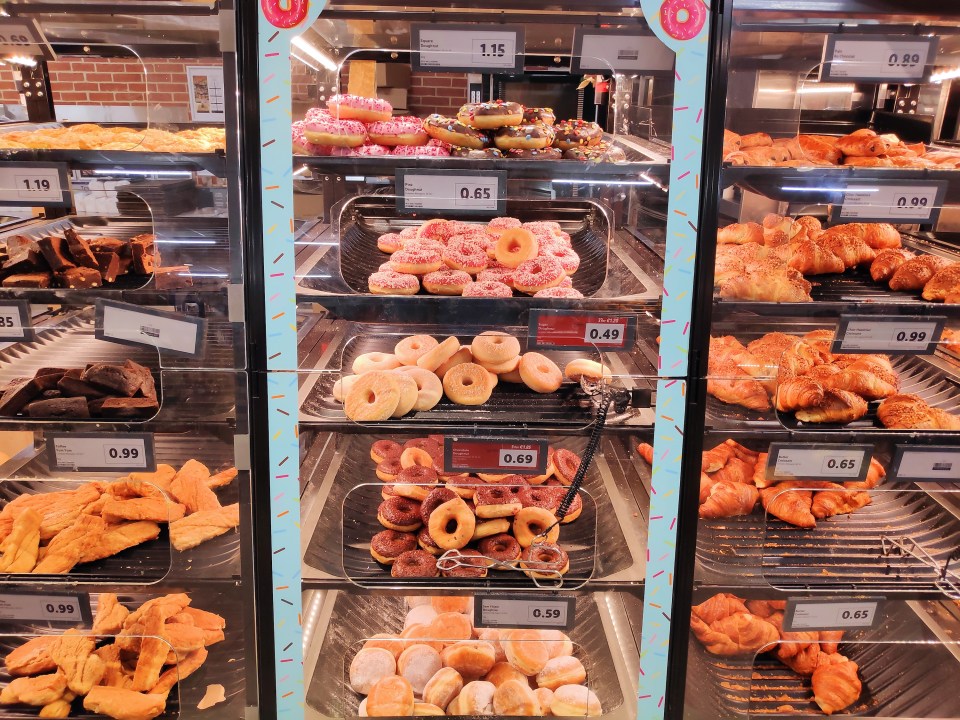 Donuts and croissants on display in a bakery.