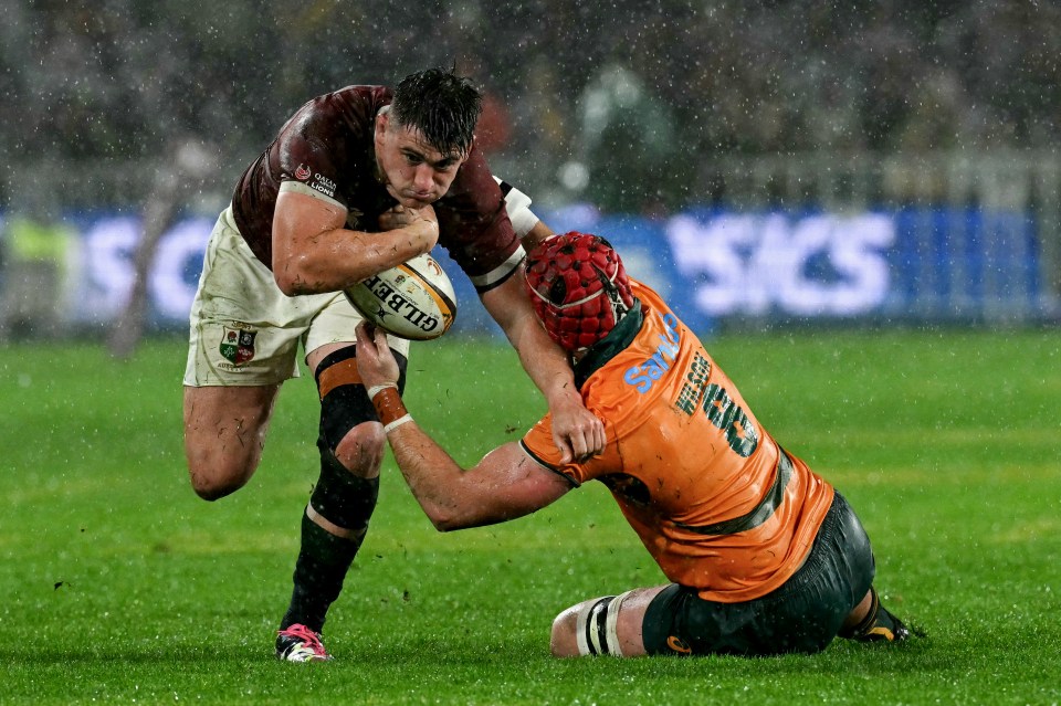 British and Irish Lions player tackled by Australia's captain Harry Wilson during a rugby match.